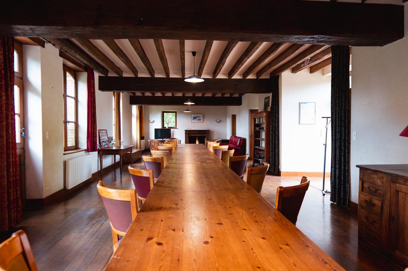Grande table en bois dans la salle aux poutres apparentes